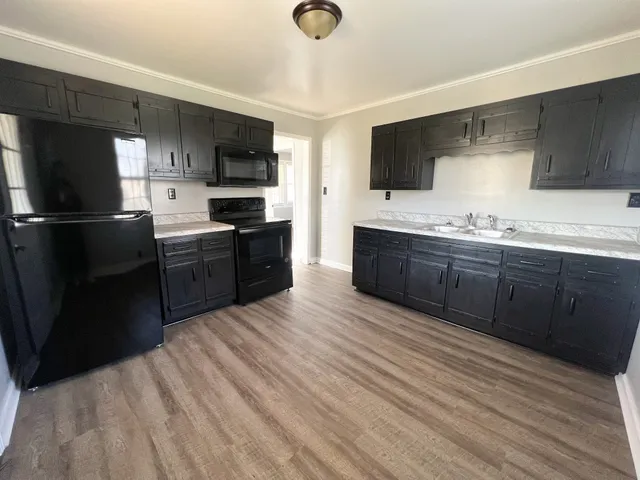 a large kitchen with stainless steel appliances granite countertop a stove a sink dishwasher and a refrigerator