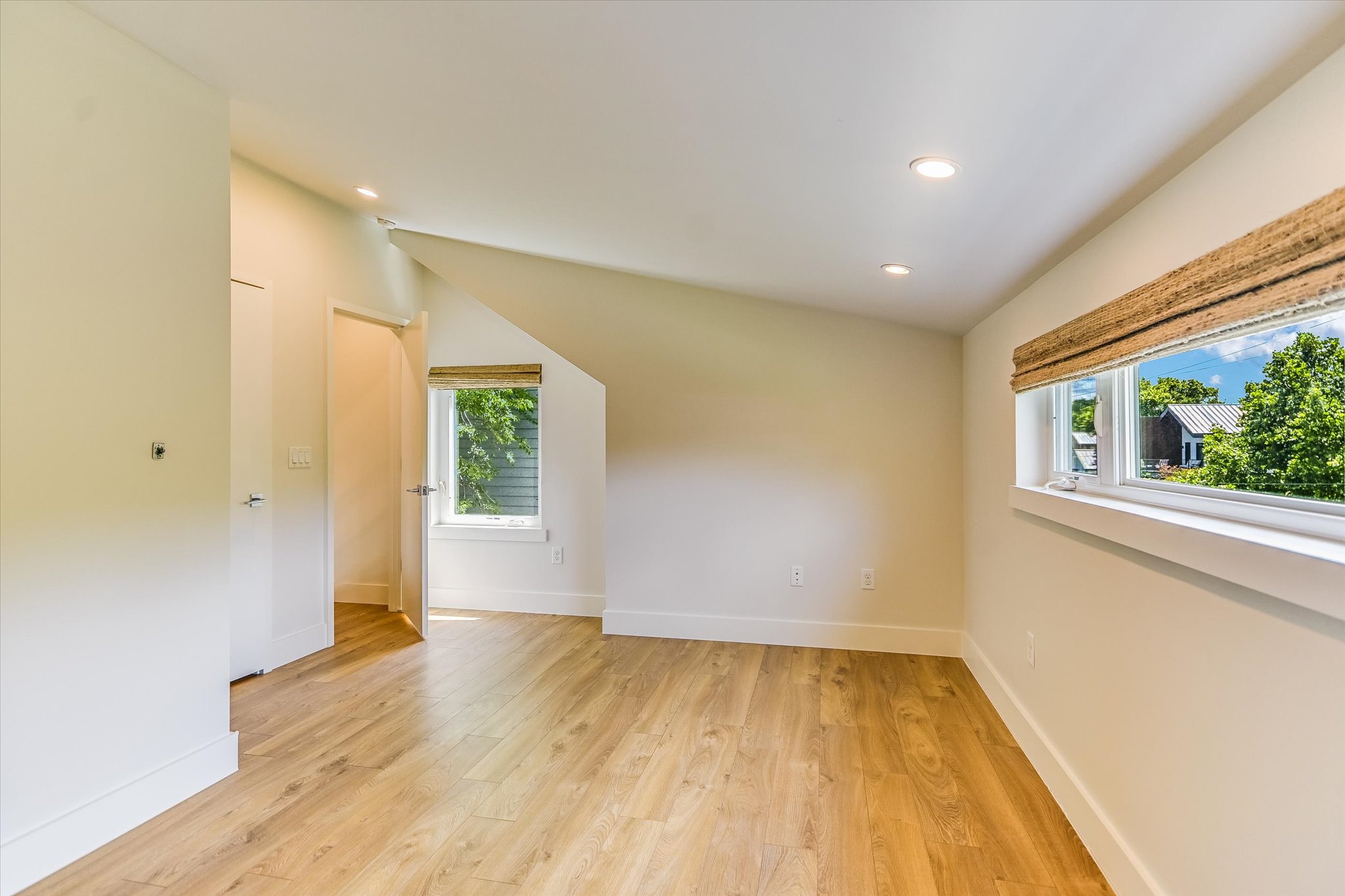 1605 Hether Street Austin, TX 78704 - Photo 23 of 26 Spacious room featuring wood-finish flooring, recessed lighting, multiple windows with natural light, and a sloped ceiling