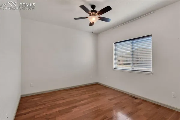 an empty room with a window and a fan
