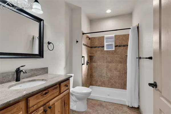 a bathroom with a granite countertop sink toilet and shower