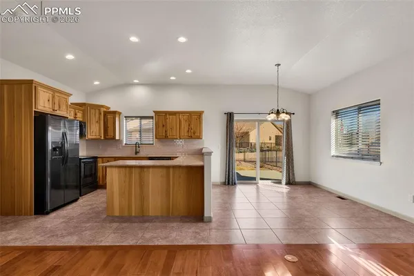 a view of kitchen with stainless steel appliances granite countertop cabinets and outdoor space