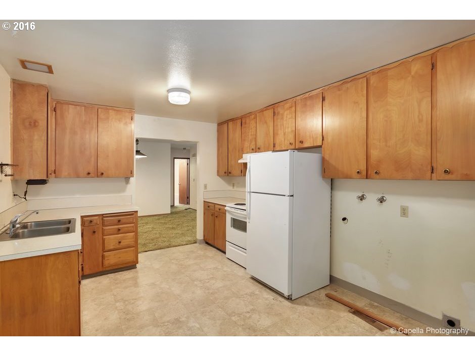19428 Northwest Logie Trail Road Portland, OR 97231 - Photo 6 of 20 a kitchen with white cabinets and stainless steel appliances