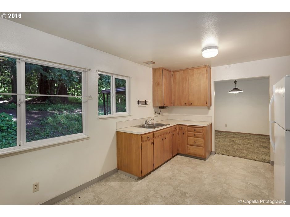 19428 Northwest Logie Trail Road Portland, OR 97231 - Photo 7 of 20 a kitchen with stainless steel appliances granite countertop a stove a sink and a refrigerator