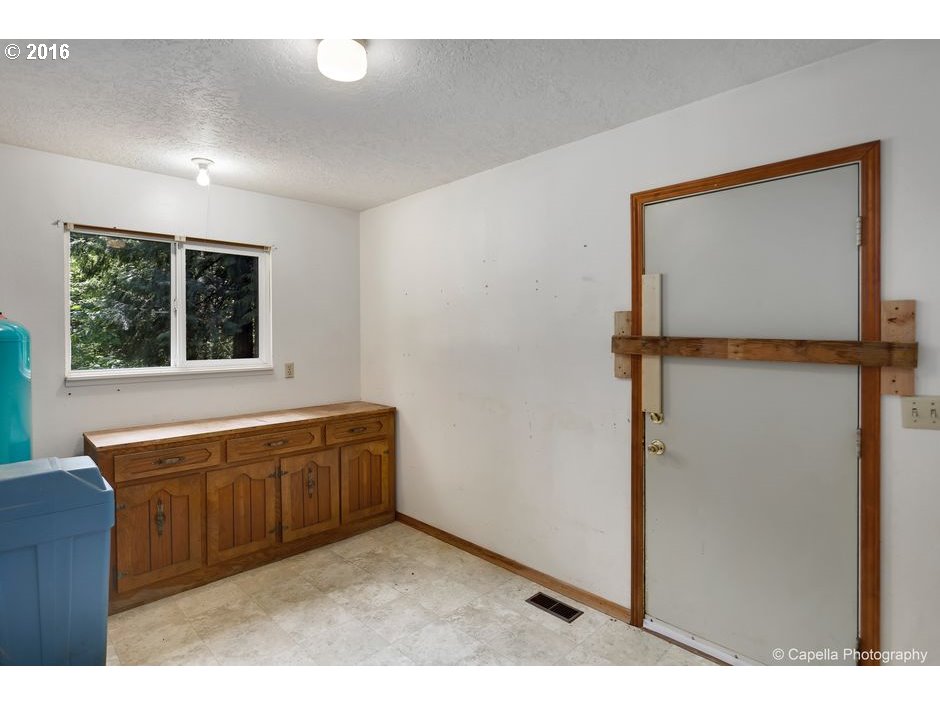 19428 Northwest Logie Trail Road Portland, OR 97231 - Photo 9 of 20 a view of an empty room with windows & cabinet