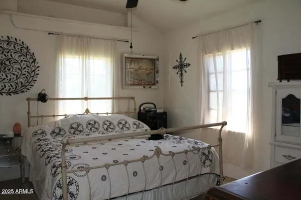 a bedroom with a bed and a flat tv screen on the dresser