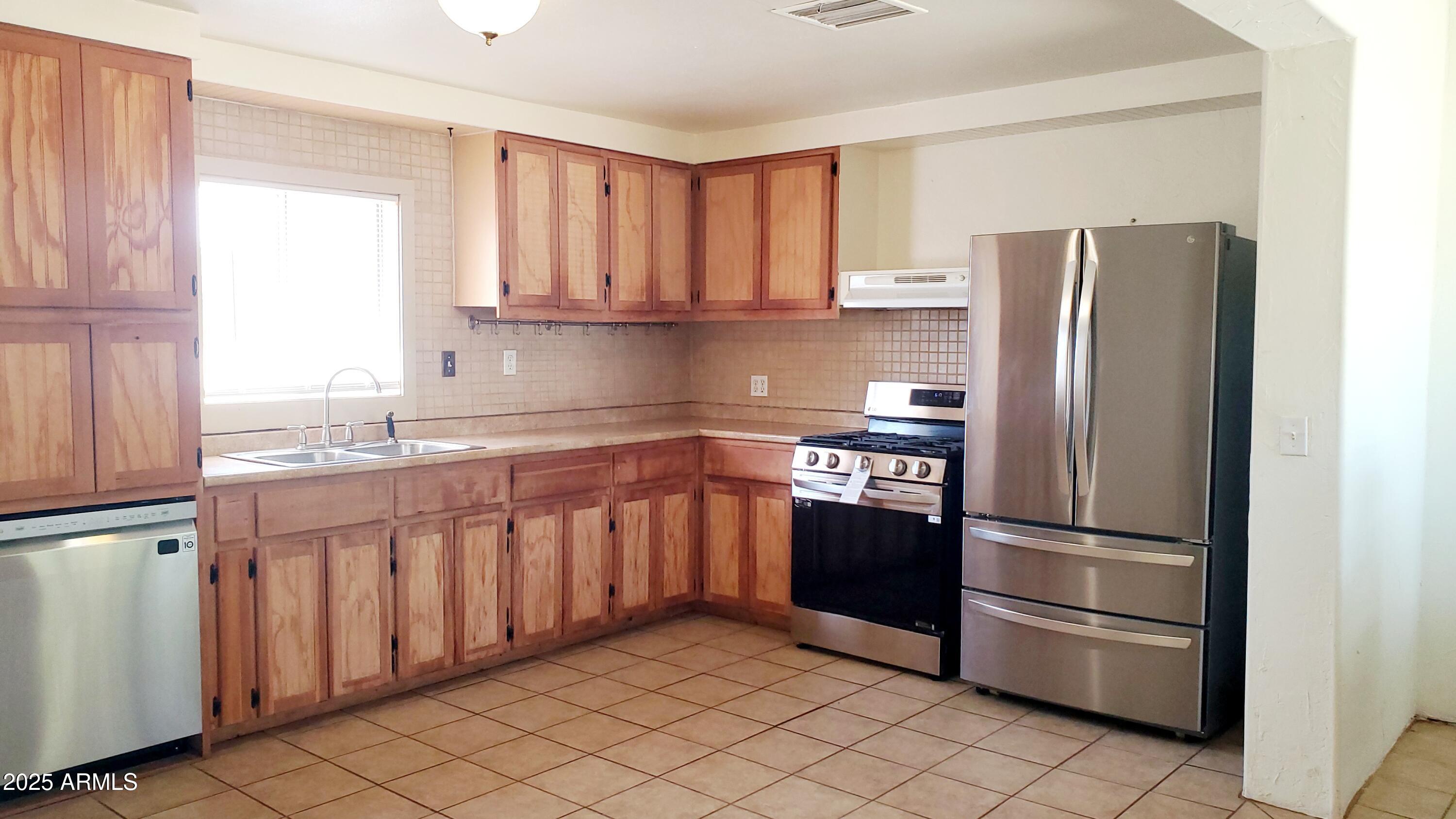1005 West Purdy Lane Bisbee, AZ 85603 - Photo 9 of 23 a kitchen with stainless steel appliances granite countertop a refrigerator and a sink