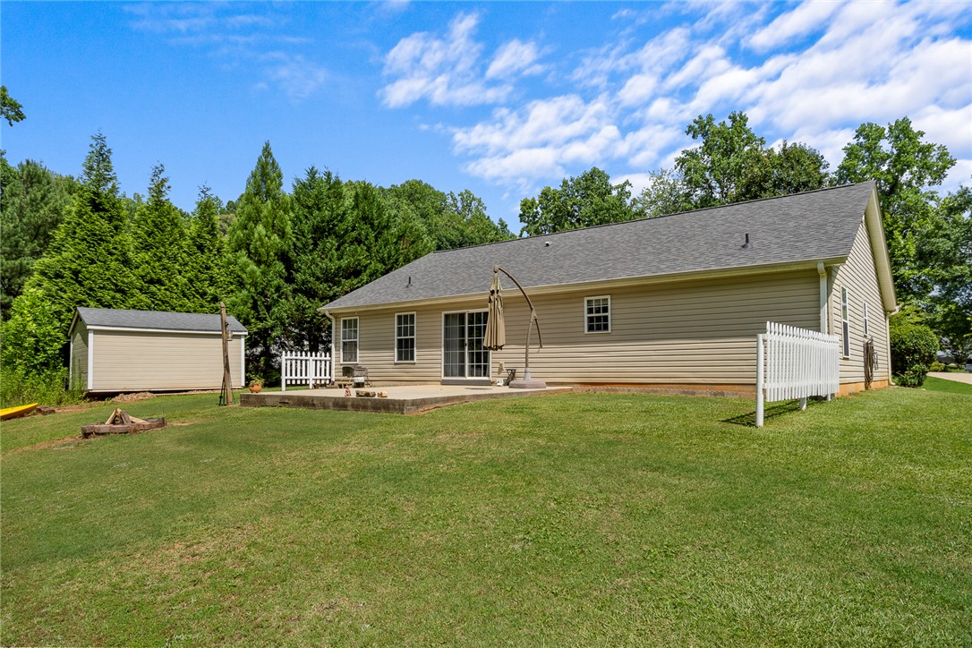 167 Mediterranean Avenue Anderson, SC 29621 - Photo 32 of 33 A spacious backyard with mature trees, a storage shed, and a ready-to-use fire pit.