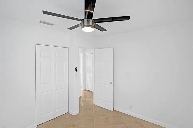 a view of a room with a chandelier fan and closet