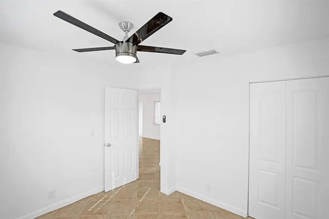a view of a hallway with a ceiling fan