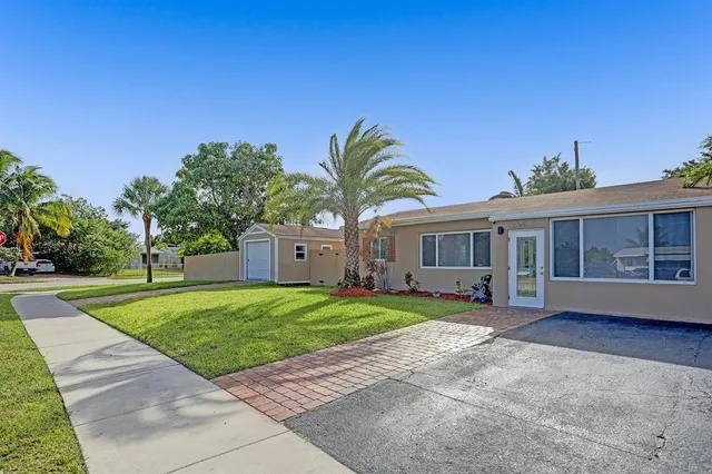 a front view of a house with a garden and trees