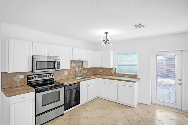 a kitchen with a sink stove and cabinets