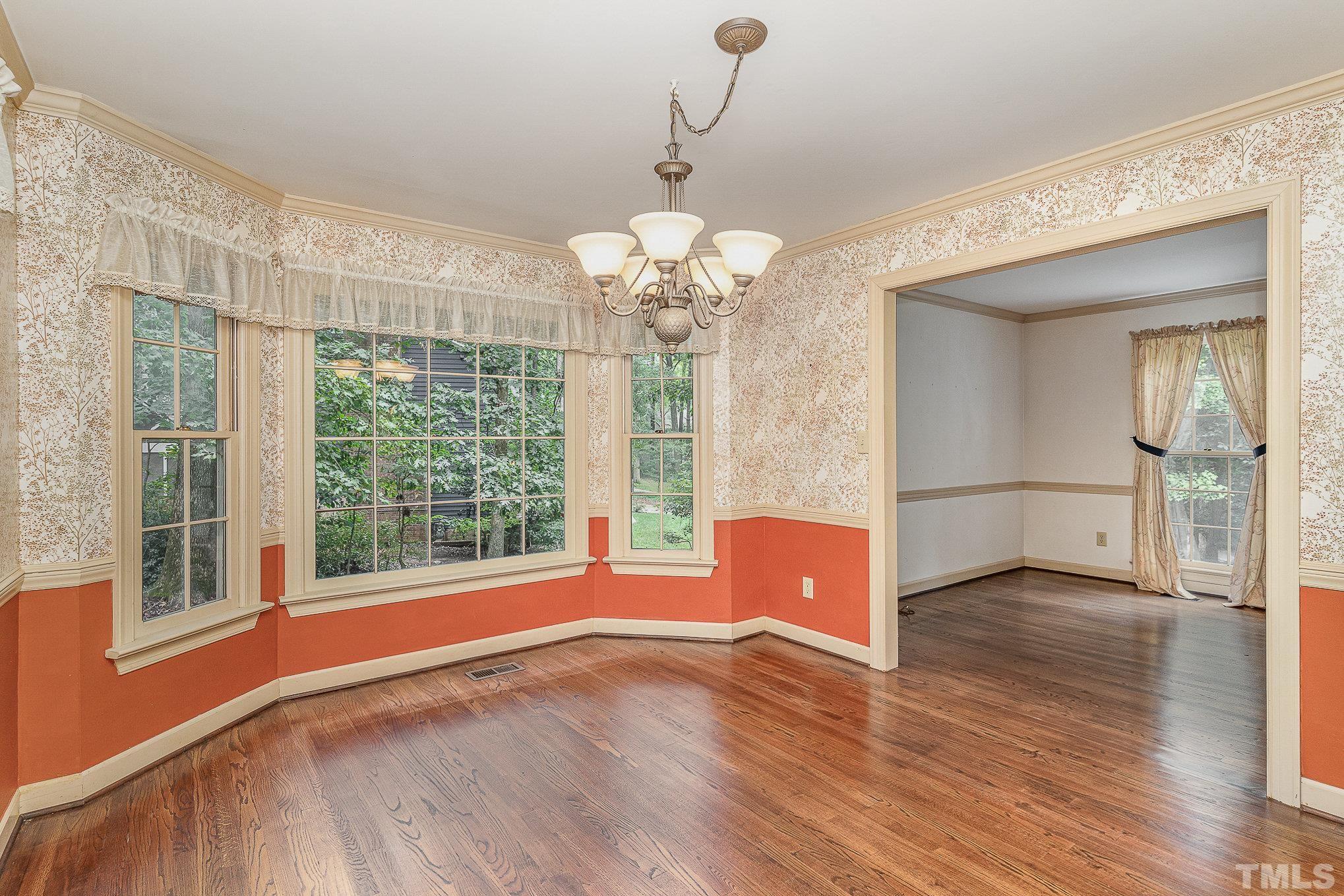 4909 Springwood Drive Raleigh, NC 27613 - Photo 12 of 59 a view of livingroom with furniture wooden floor and chandelier