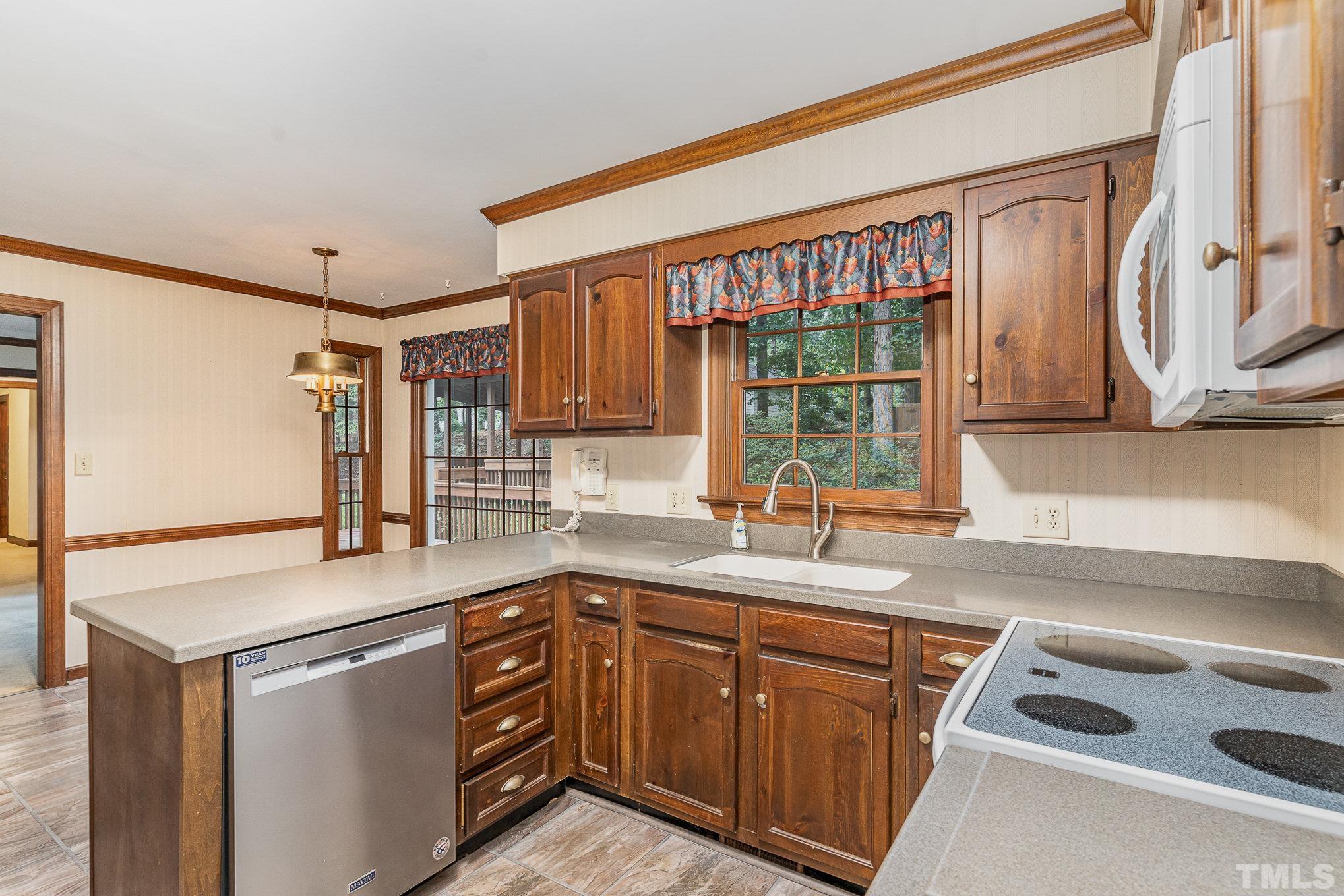 4909 Springwood Drive Raleigh, NC 27613 - Photo 13 of 59 a kitchen with stainless steel appliances granite countertop a sink stove and cabinets