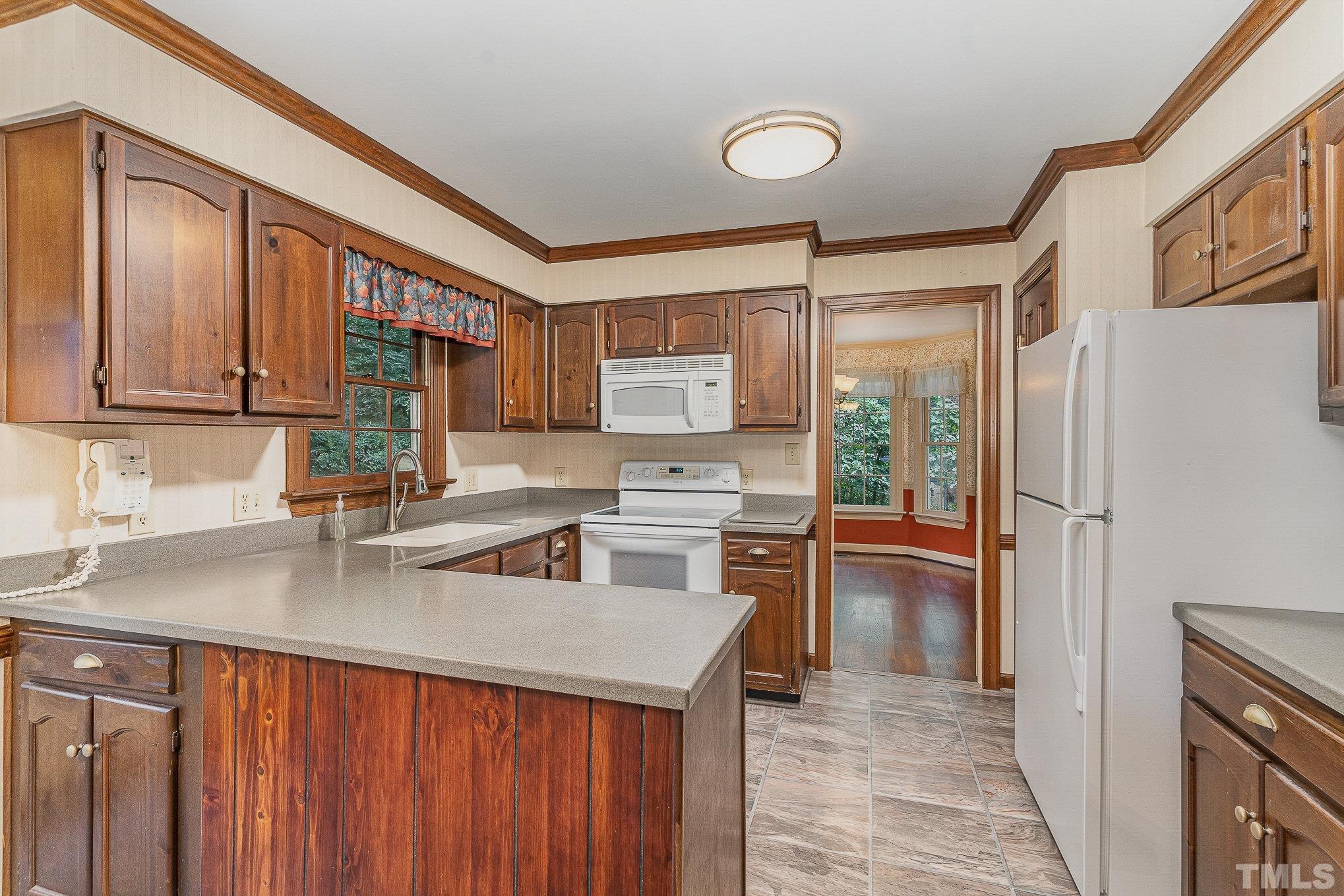 4909 Springwood Drive Raleigh, NC 27613 - Photo 15 of 59 a kitchen with stainless steel appliances granite countertop a refrigerator a sink dishwasher a stove with wooden cabinets and floor