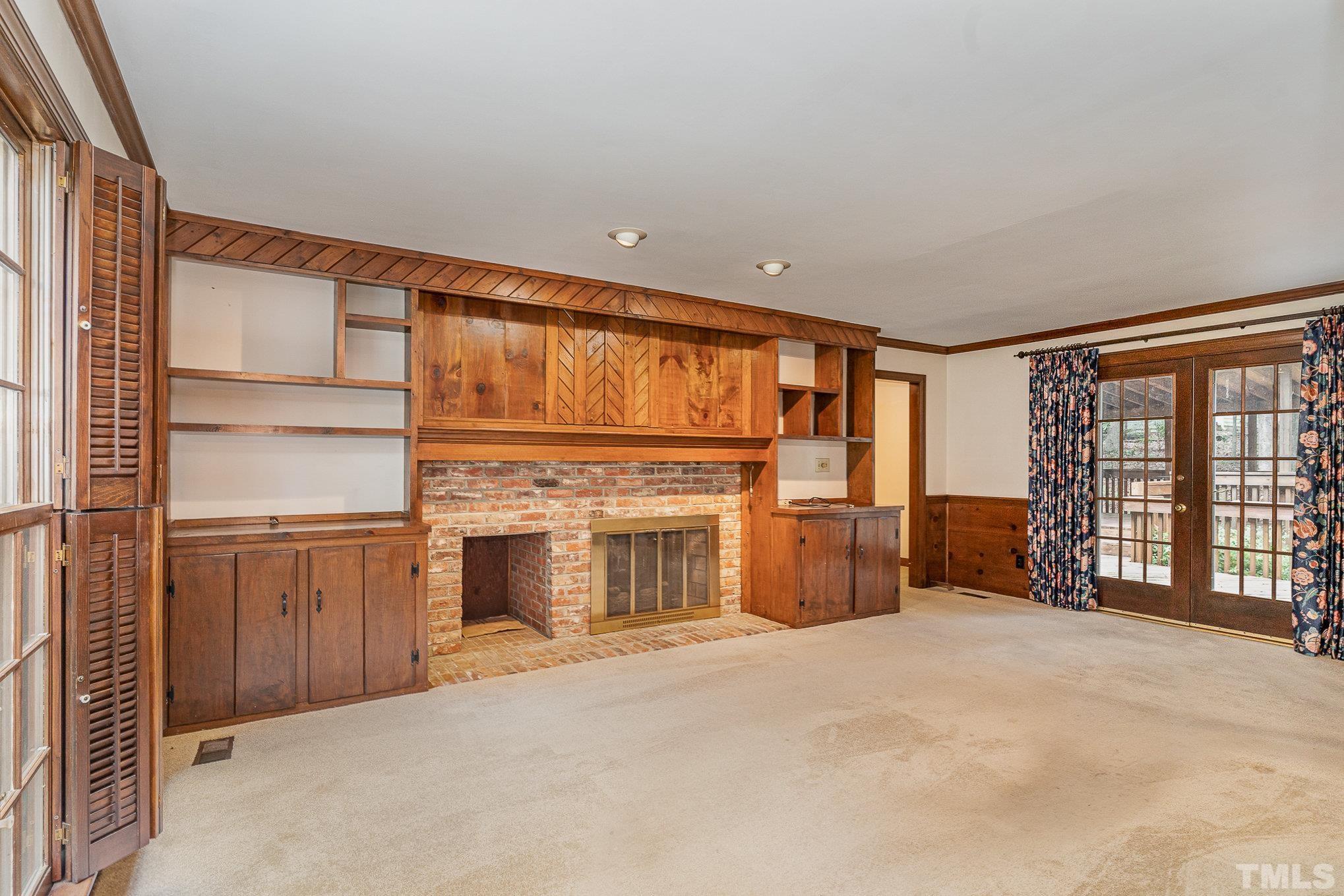 4909 Springwood Drive Raleigh, NC 27613 - Photo 19 of 59 a view of an empty room with a fireplace and a window