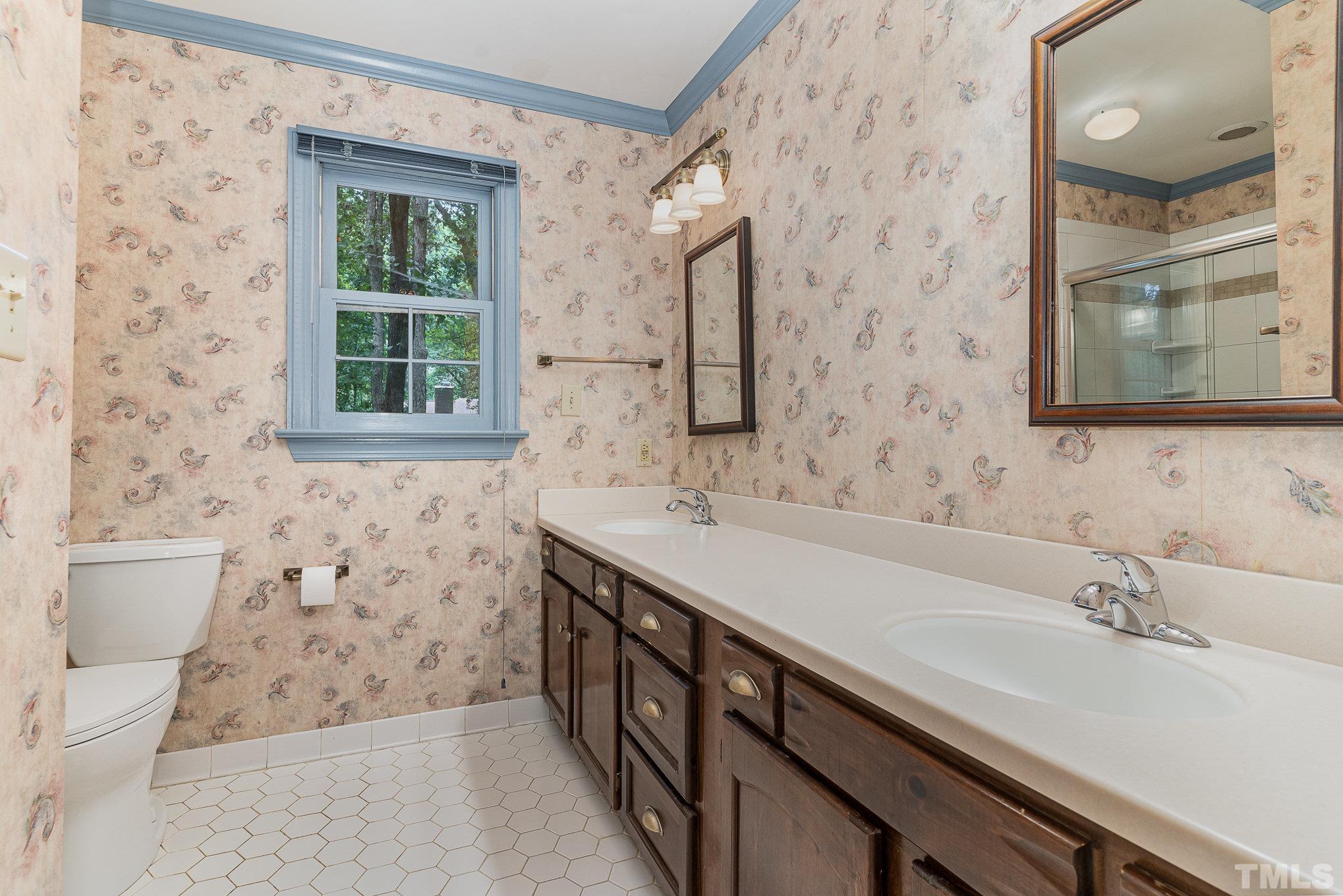 4909 Springwood Drive Raleigh, NC 27613 - Photo 34 of 59 a bathroom with a sink a toilet and a mirror