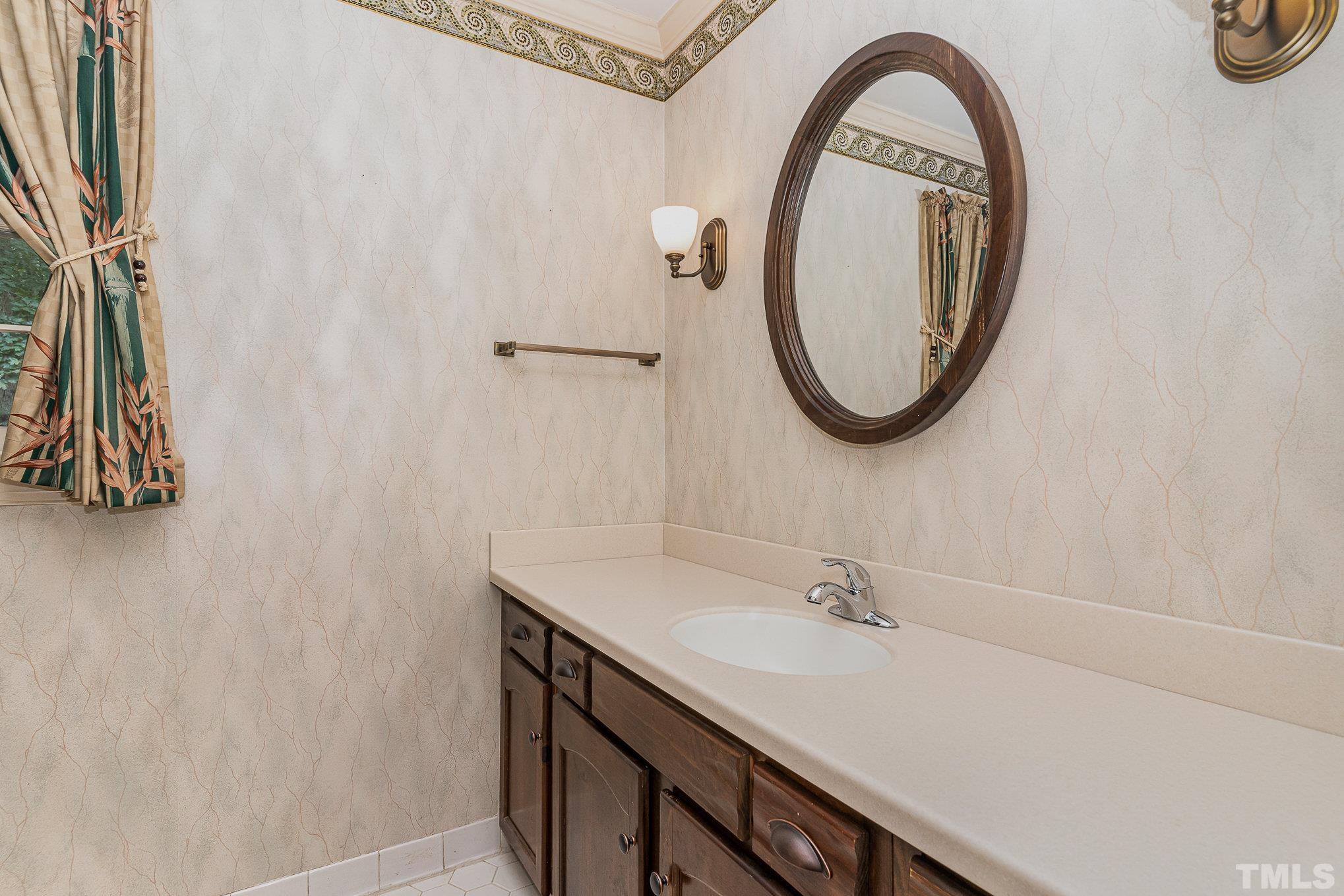 4909 Springwood Drive Raleigh, NC 27613 - Photo 40 of 59 a bathroom with a sink and a mirror