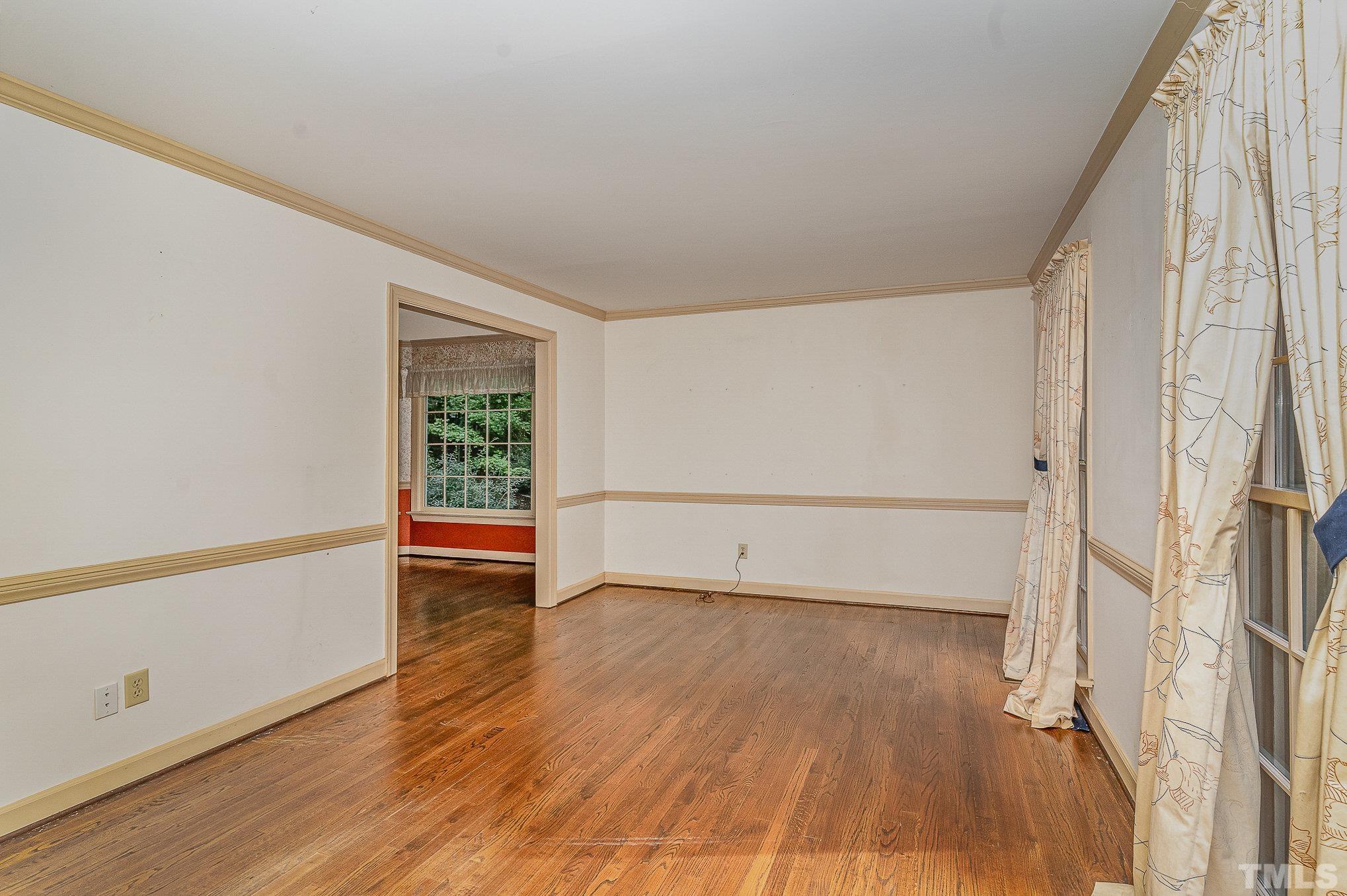4909 Springwood Drive Raleigh, NC 27613 - Photo 6 of 59 an empty room with wooden floor and windows