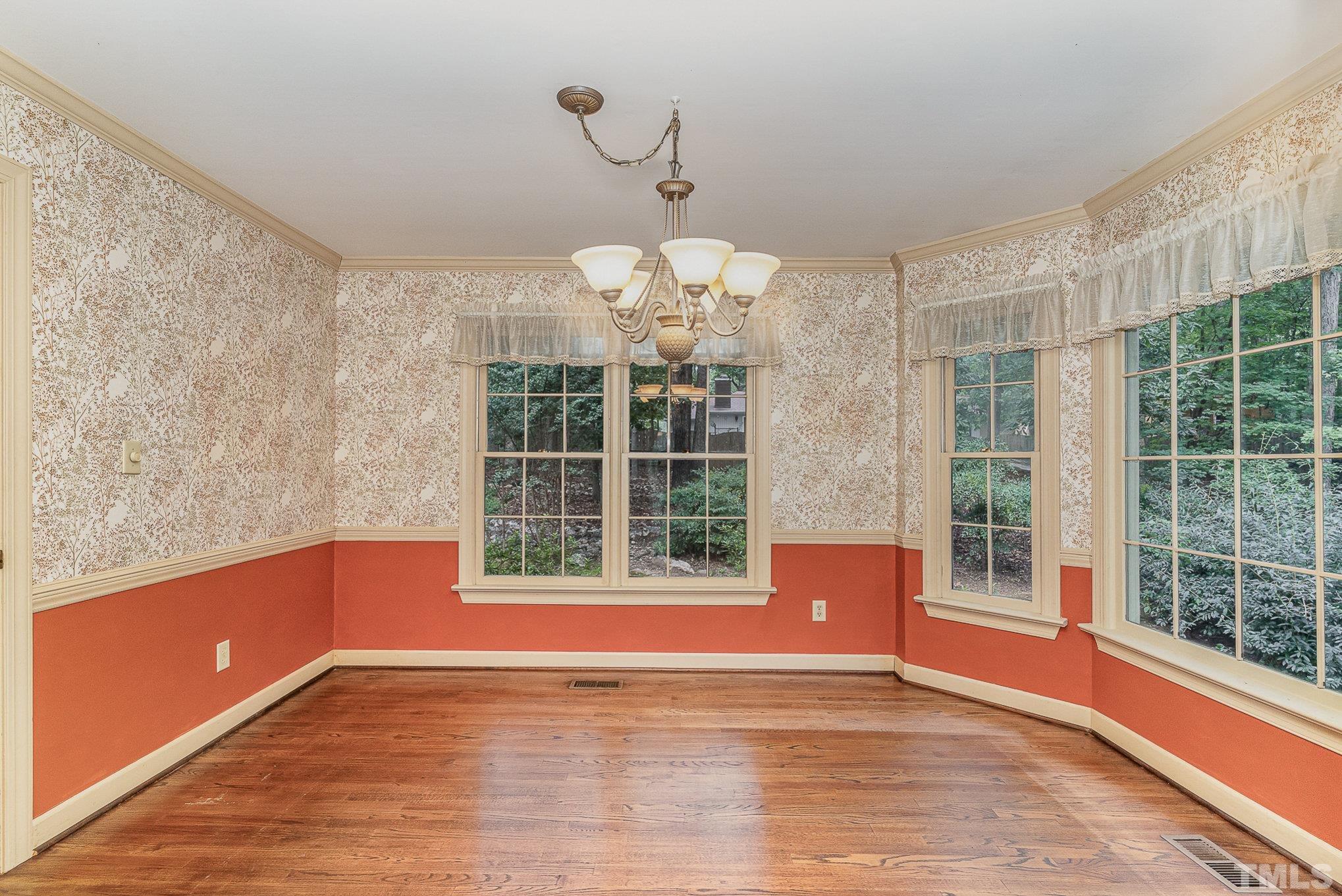 4909 Springwood Drive Raleigh, NC 27613 - Photo 10 of 59 a view of an empty room with a window and wooden floor