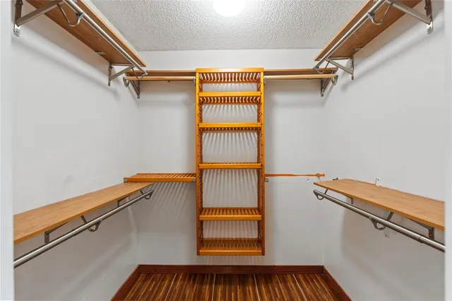a view of walk in closet with clothes and shoes