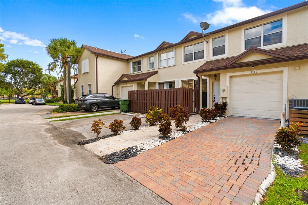 9580 Southwest 2nd Ct., Unit 9580 Pembroke Pines, FL 33025 - Photo 28 of 33 a view of a white house with large windows and couches chairs
