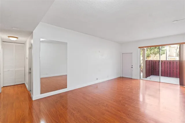 an empty room with wooden floor and sliding door