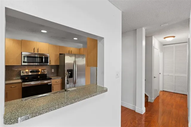 a kitchen with stainless steel appliances granite countertop a refrigerator and a sink