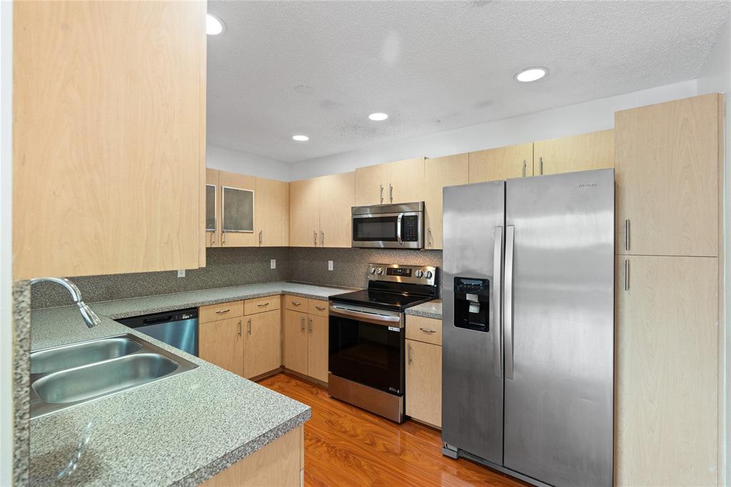 9580 Southwest 2nd Ct., Unit 9580 Pembroke Pines, FL 33025 - Photo 8 of 33 a kitchen with stainless steel appliances granite countertop a refrigerator a sink a stove and oven