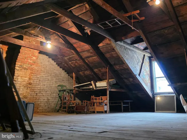 a white toilet sitting next to a sink and wooden floor