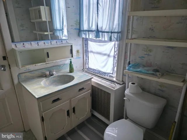 a bathroom with a granite countertop toilet sink and mirror