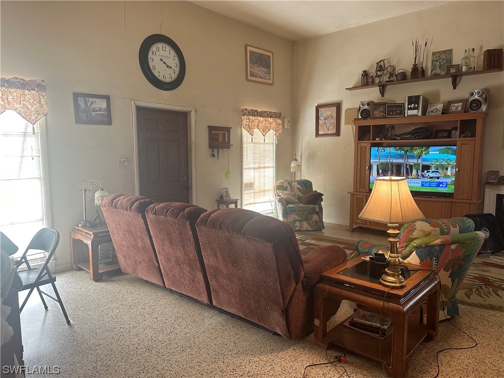 22841 North River Road Alva, FL 33920 - Photo 15 of 23 a living room with furniture a clock on wall and a window