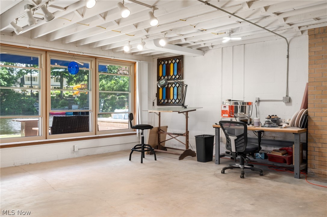 685 Sunnyside Road Vermilion, OH 44089 - Photo 31 of 50 Expansive room featuring multiple large windows, exposed ceiling joists, track lighting, and a partial brick wall accent