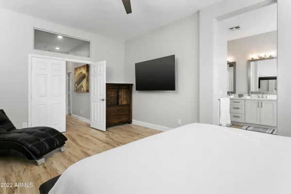 a bedroom with a bed and a flat tv screen on wall