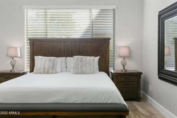 a large bed sitting in a bedroom next to a window and dresser