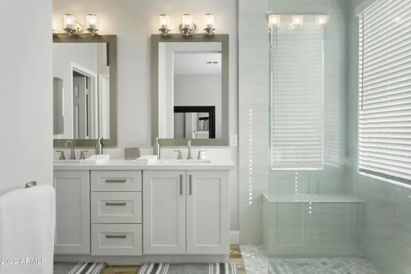 a bathroom with a double vanity sink and a mirror