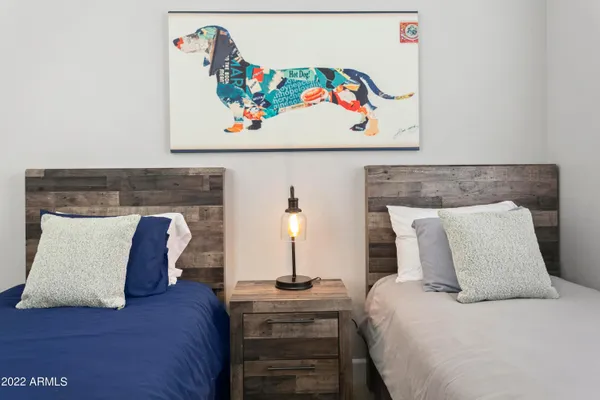 a bedroom with a bed and painting on the wall