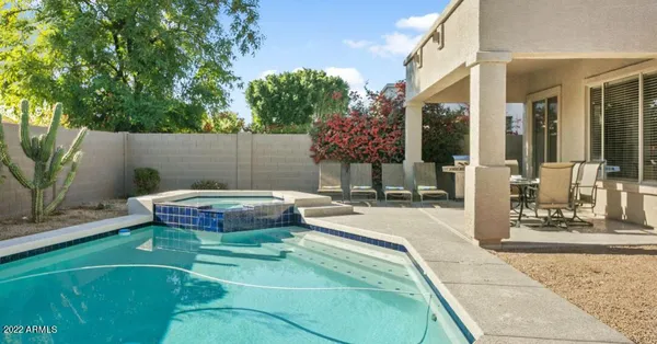 a backyard of a house with table and chairs