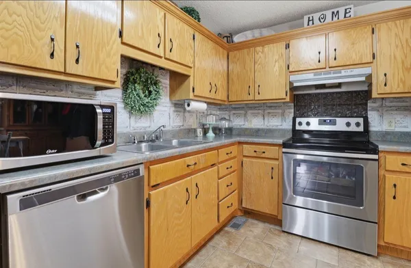 a kitchen with stainless steel appliances granite countertop a stove microwave and cabinets