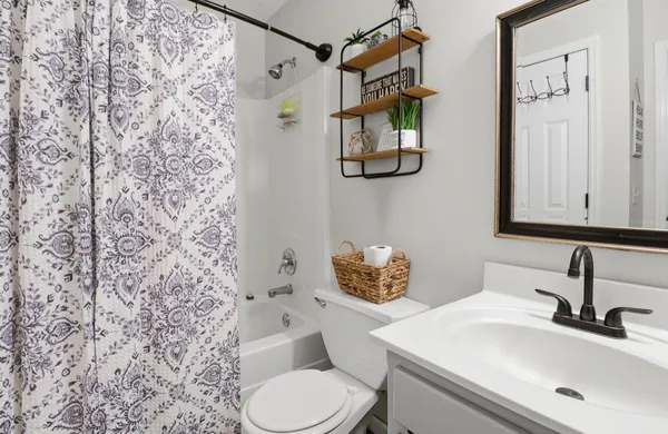 a bathroom with a sink a toilet and shower curtain