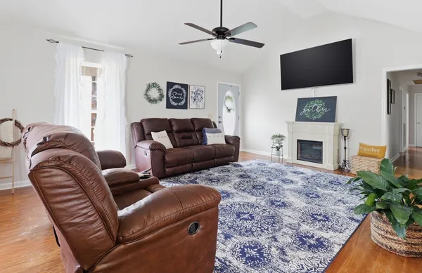 a living room with furniture a flat screen tv and a fireplace
