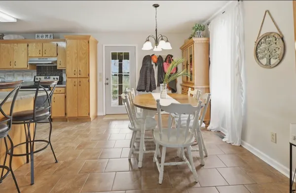 a dining area with a table chairs and a kitchen view