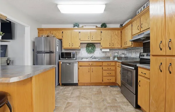a kitchen with stainless steel appliances granite countertop a refrigerator sink and stove