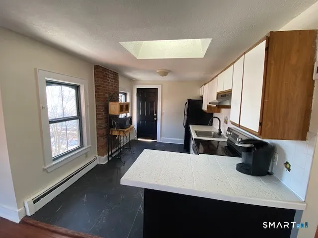 a living room with furniture a flat screen tv and a window