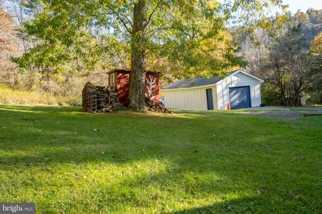 a view of a house with backyard and tree
