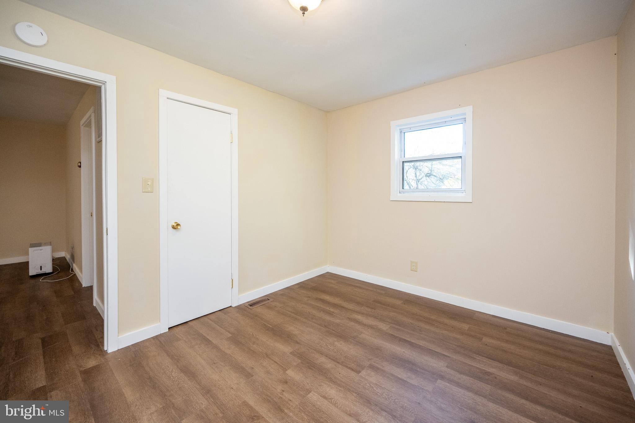 63 Wallman Road Oakland, MD 21550 - Photo 39 of 60 an empty room with wooden floor and windows