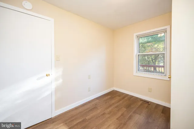 a view of an empty room with wooden floor