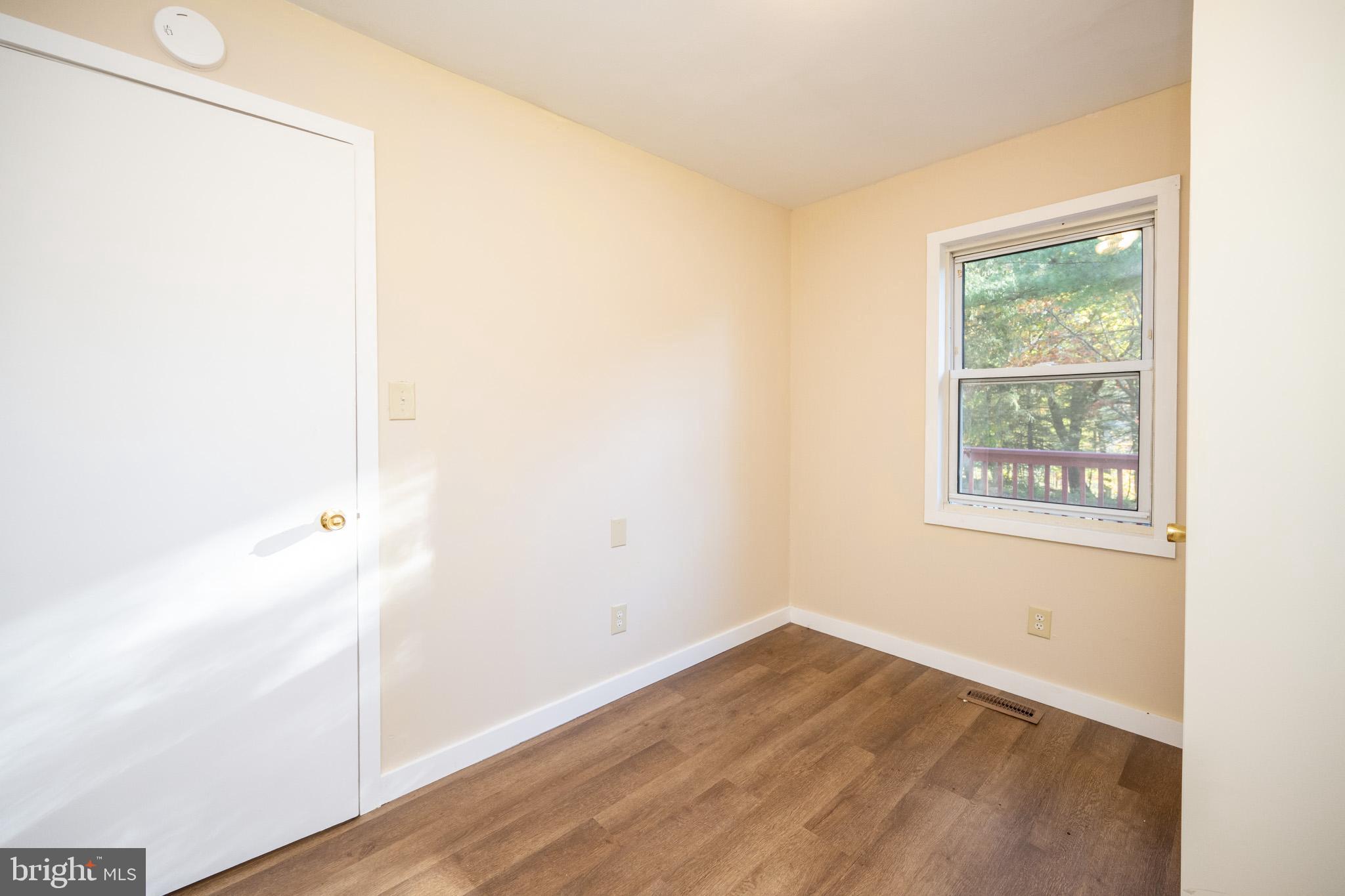 63 Wallman Road Oakland, MD 21550 - Photo 42 of 60 a view of an empty room with wooden floor and a window