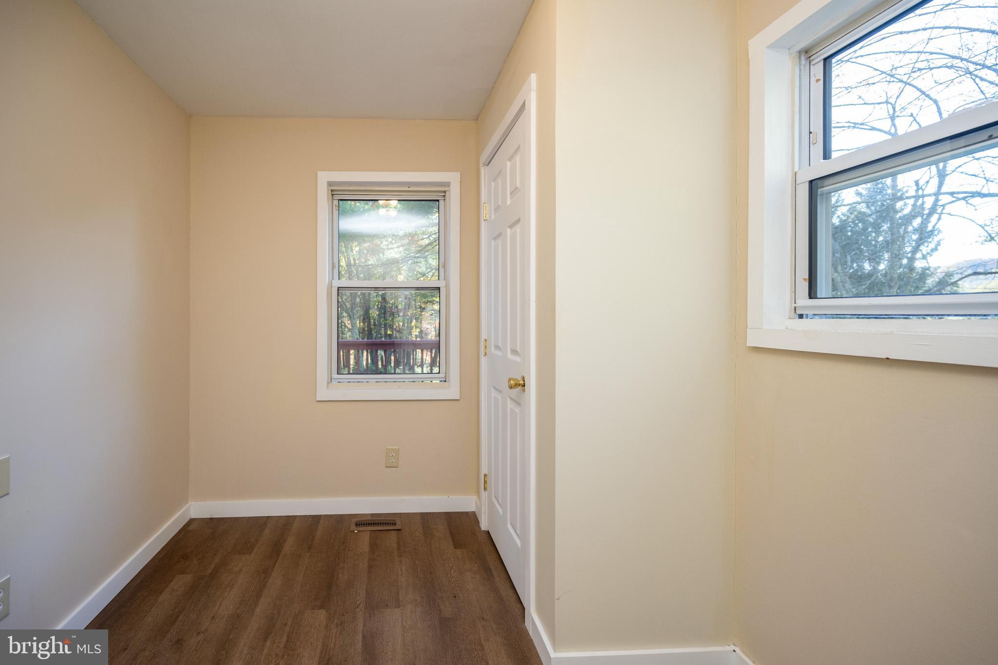 63 Wallman Road Oakland, MD 21550 - Photo 43 of 60 a view of an empty room with a window and wooden floor