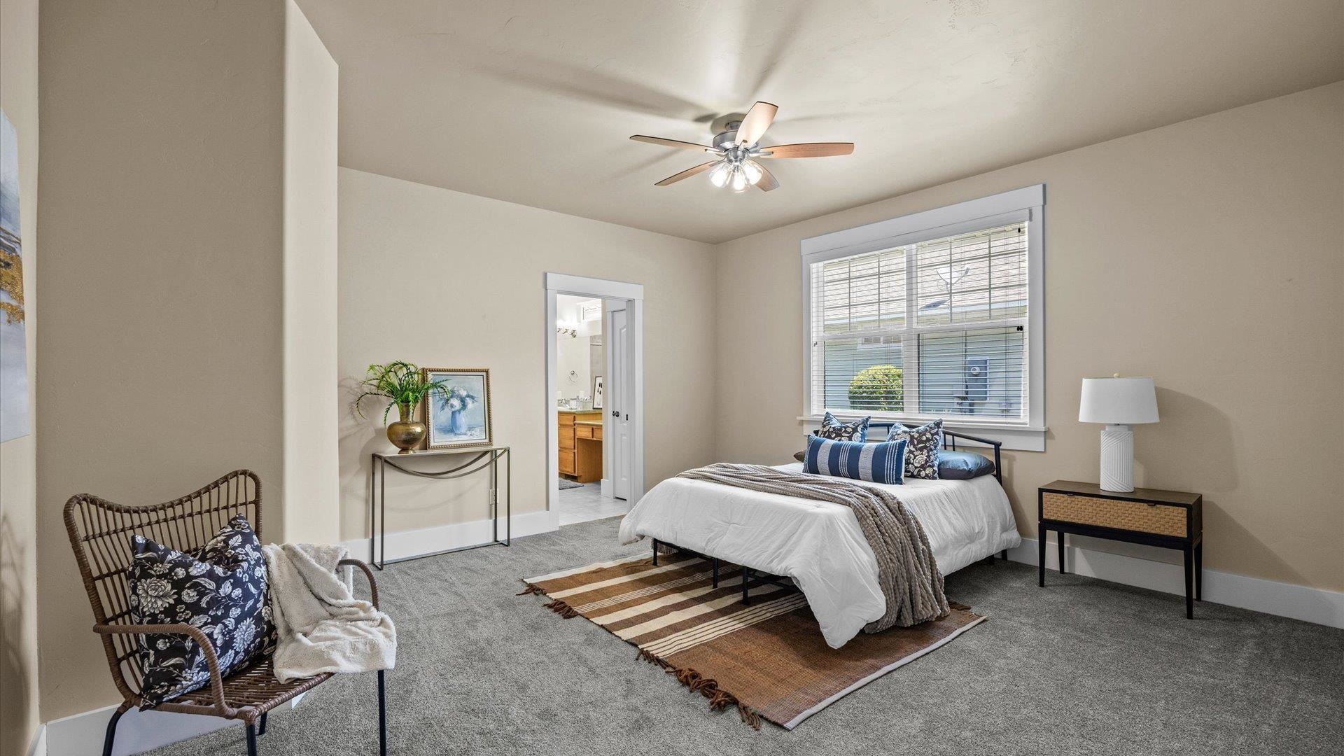 1115 Sunrose Lane Fruita, CO 81521 - Photo 13 of 32 a bedroom with a bed and a chandelier