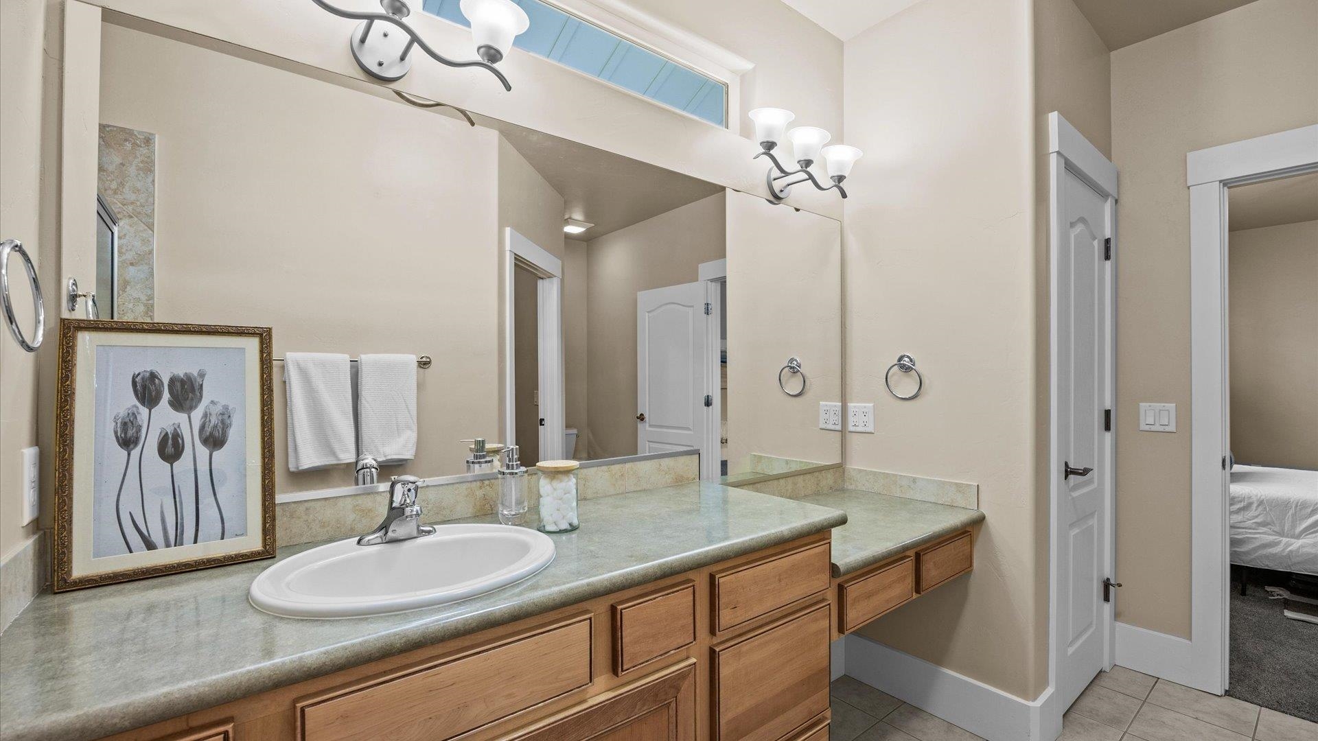 1115 Sunrose Lane Fruita, CO 81521 - Photo 14 of 32 a bathroom with a granite countertop sink a large mirror and a shower